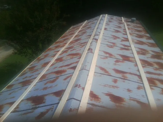 Rusted metal roof panels with new wood purlins before replacement — Storm Damage Roof Repair in Williston by Roofing Brothers